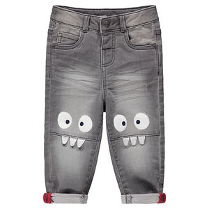 Vaqueros grises con efecto desgastado y arrugado con monstruos estampados en las rodillas 