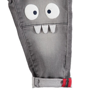 Vaqueros grises con efecto desgastado y arrugado con monstruos estampados en las rodillas 