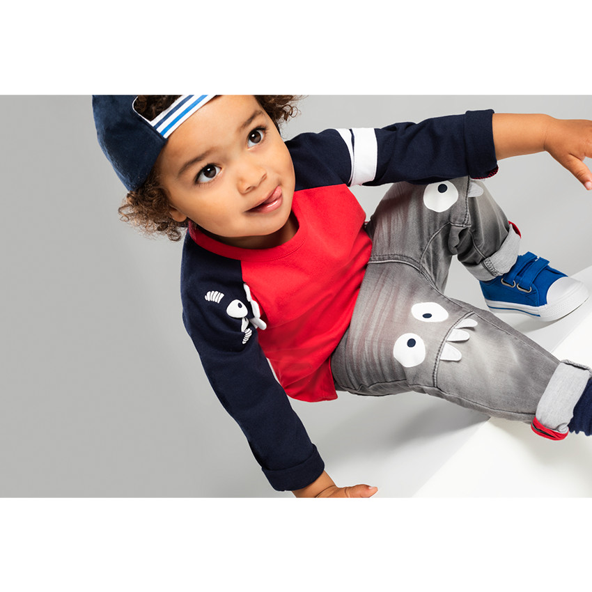 Vaqueros grises con efecto desgastado y arrugado con monstruos estampados en las rodillas 