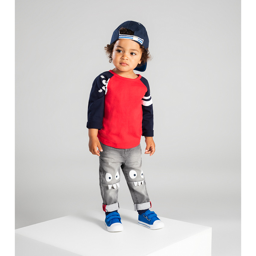 Vaqueros grises con efecto desgastado y arrugado con monstruos estampados en las rodillas 