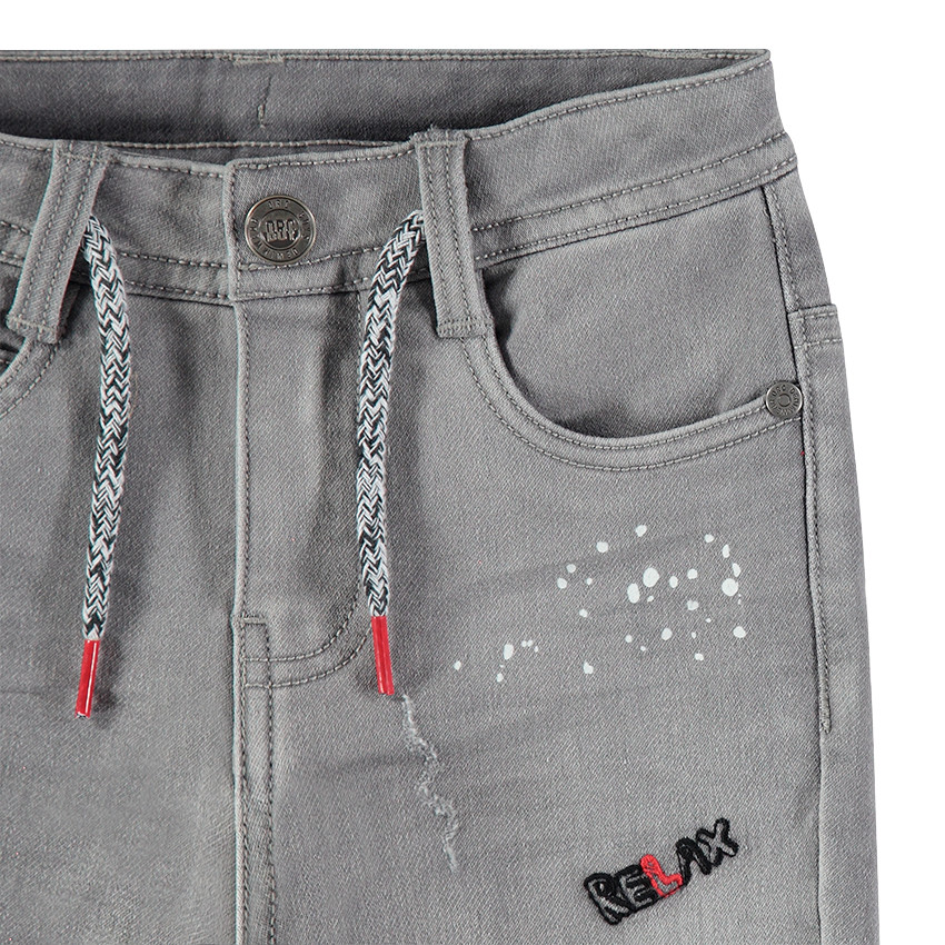 Vaqueros con efecto desgastado con manchas y parches cosidos 