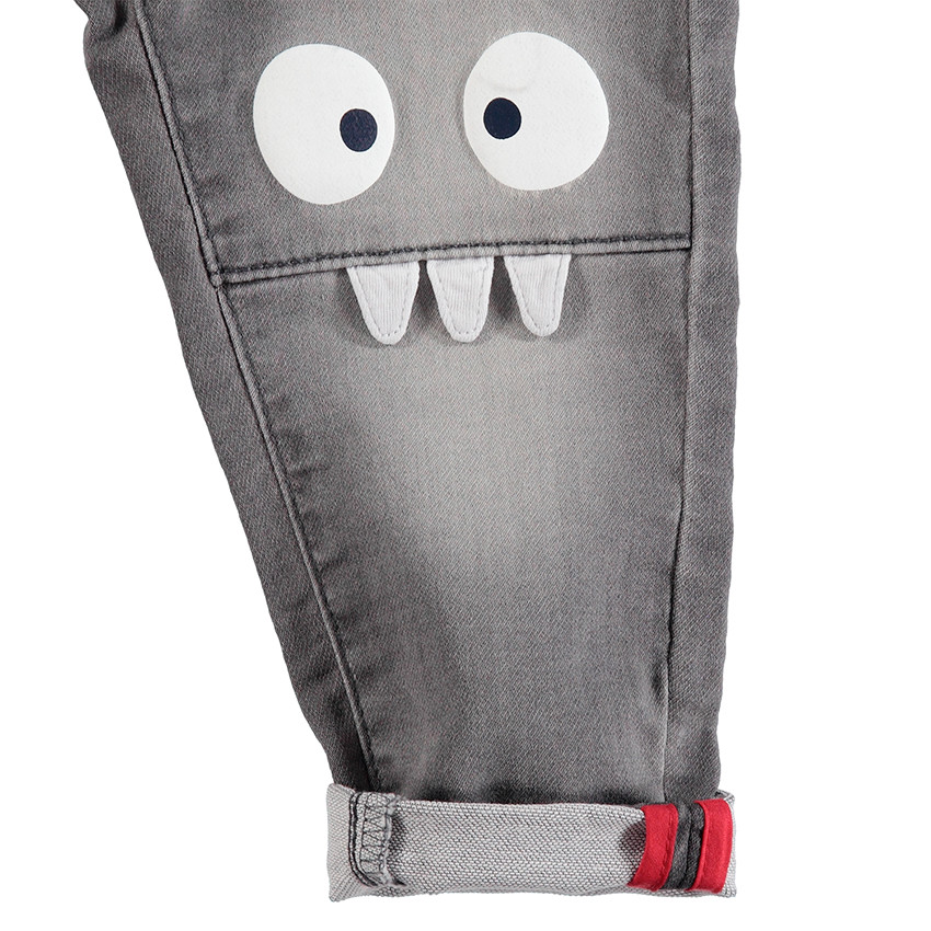 Vaqueros grises con efecto desgastado y arrugado con monstruos estampados en las rodillas 